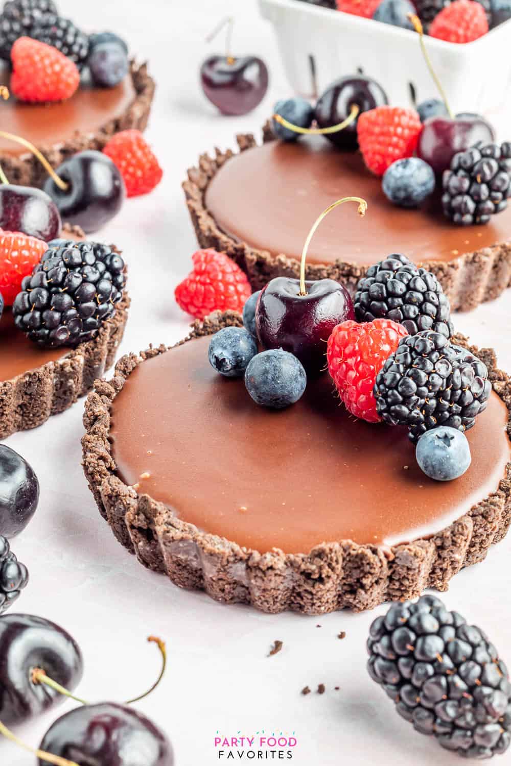 oreo crust tart with a smooth chocolate filling topped with berries