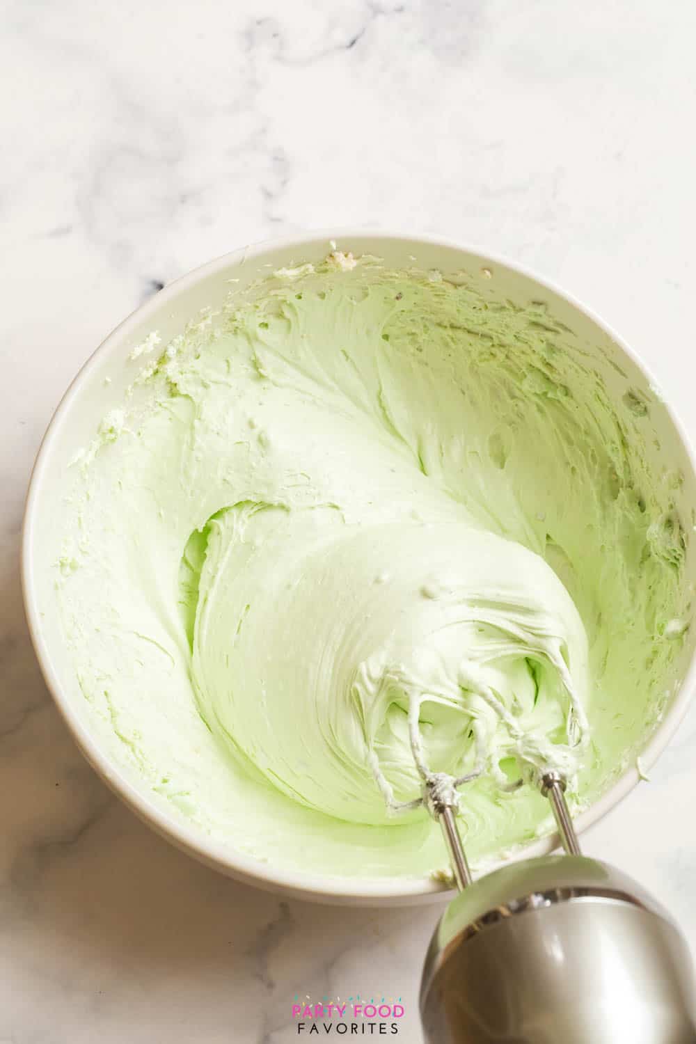 beating cream cheese with cool whip and pistachio instant pudding