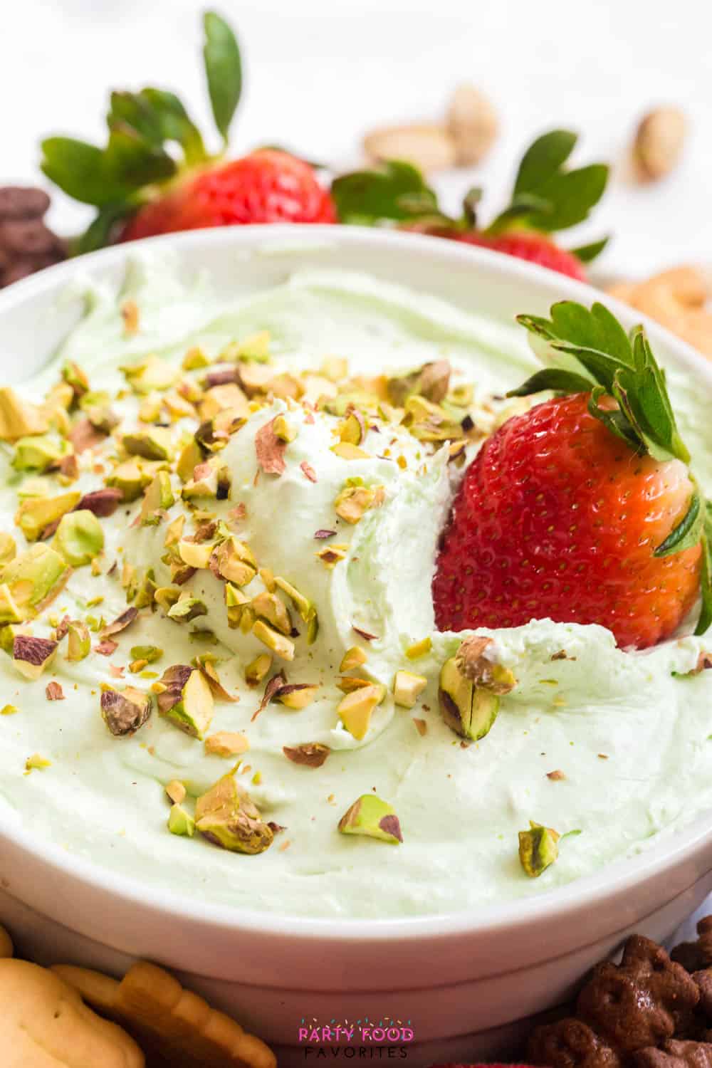 strawberry being dipped into pistachio fruit dip