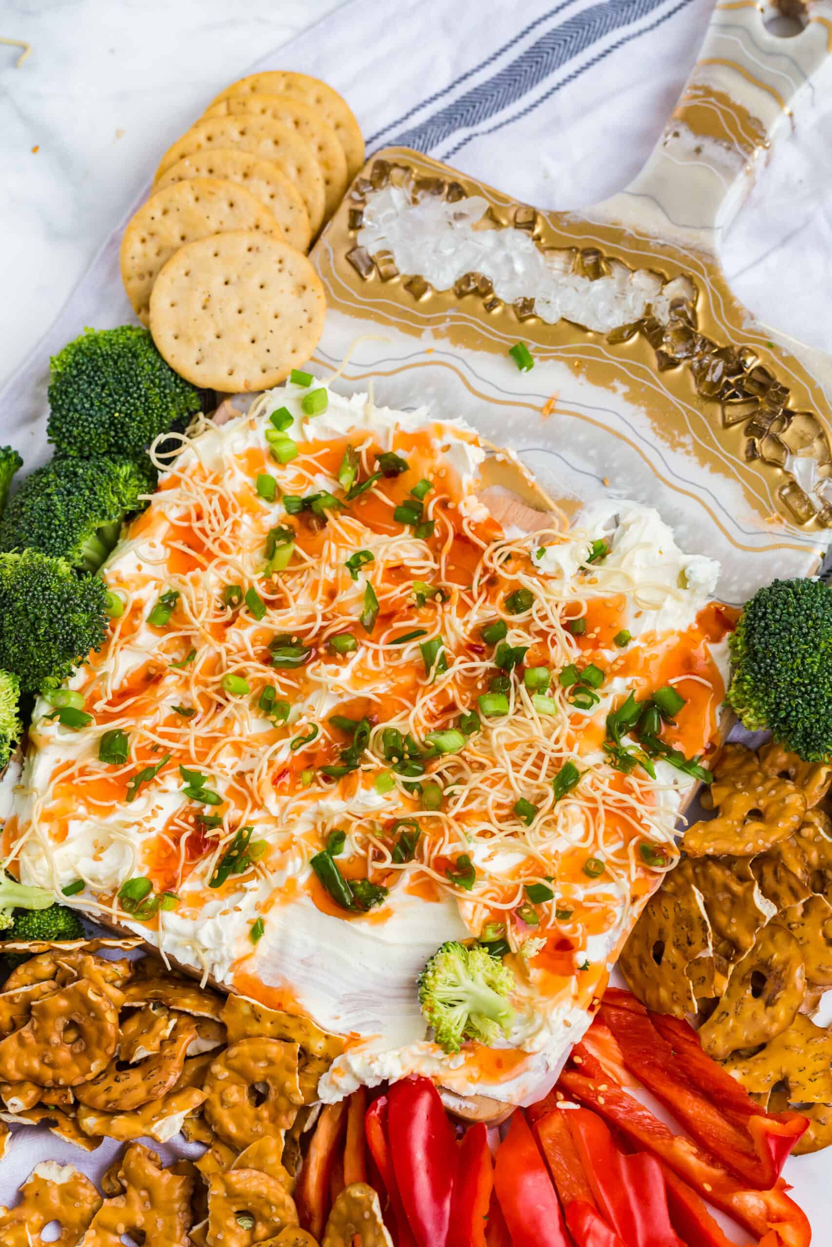 thai chili cream cheese board surrounded by vegetables and crackers