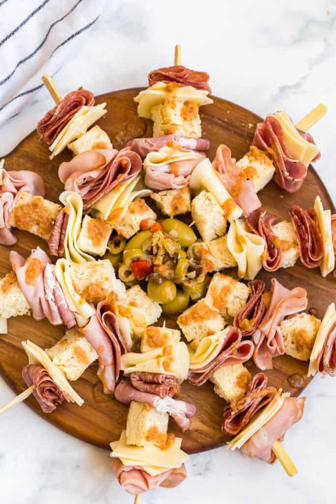 salami, mortadella, capicoli, provolne, mozzarella, and toasted baguette added to a skewer on a platter